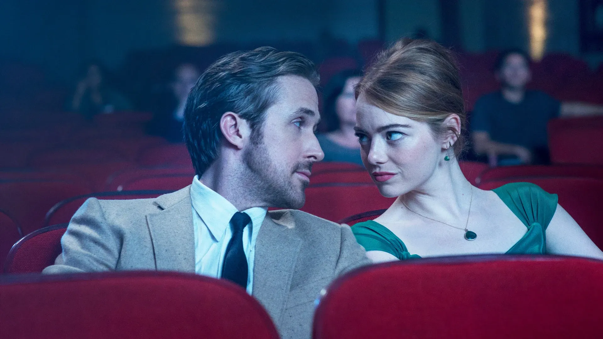 Ryan Gosling and Emma Stone staring at each other in the cinema in the film La La Land.
